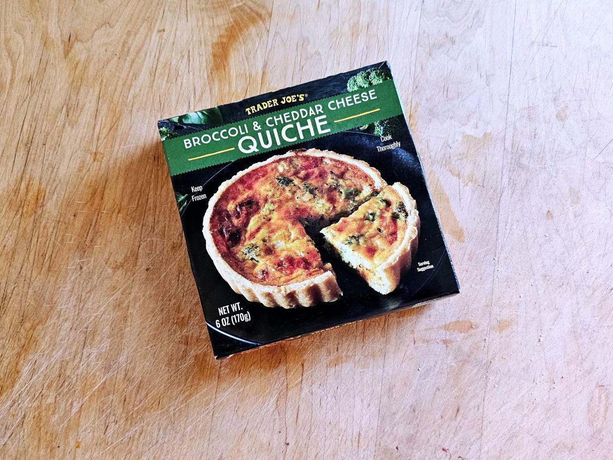 A box of Trader Joe's broccoli-and-cheddar-cheese quiche on a wooden background.