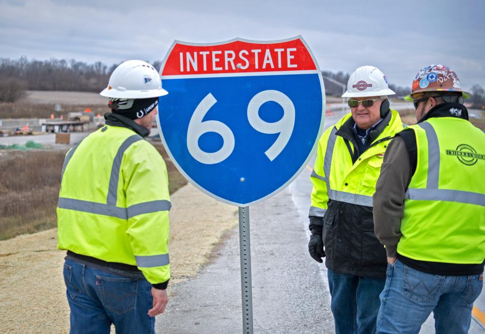 Workers check out the newest I-69 entrance ramp sign after a press conference Friday, Dec. 16, 2022 at the I-69/S.R. 144 interchange. Twelve finished miles of the new I-69 interstate between Martinsville and S.R. 144 and the interchange are now open.