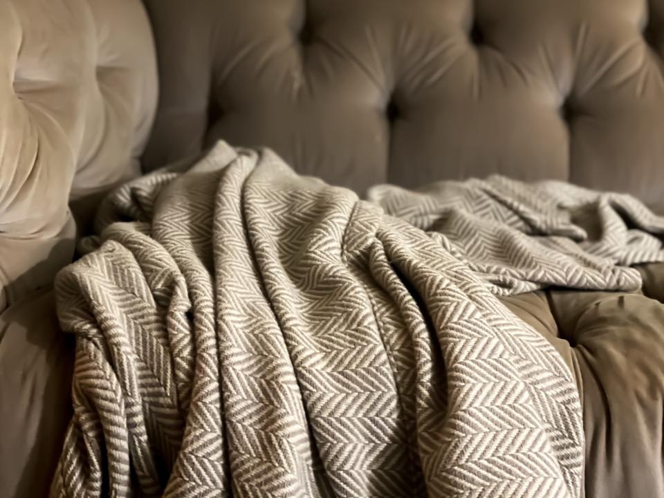 Brown and white throw blanket on brown sofa