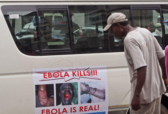 A man reads a warning about Ebola on a van door in Liberia. (AP Photo/Abbas Dulleh)