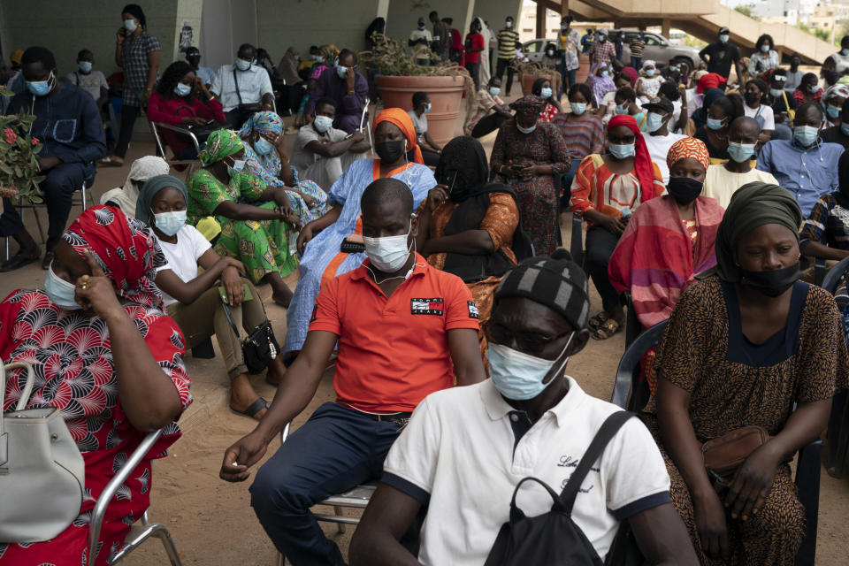 FILE- In this Wednesday, July 28, 2021 file photo, people wait to be vaccinated J at Leopold Sedar Senghor stadium in Dakar, Senegal. Thousands of new coronavirus cases have been reported in West Africa in recent weeks amid low vaccination rates and the spread of the delta variant. (AP Photo/Leo Correa, File)