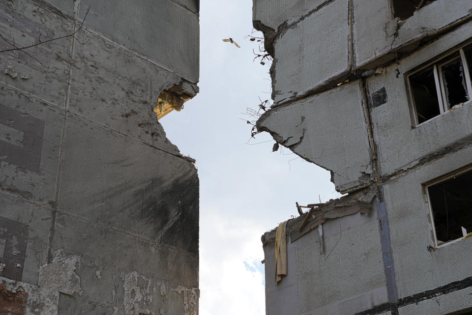 A bird flies between two missile-damaged buildings ahead of a visit by Ukrainian President Volodymyr Zelenskyy in Zaporizhzhia, Ukraine, Monday March 27, 2023. (AP Photo/Efrem Lukatsky)