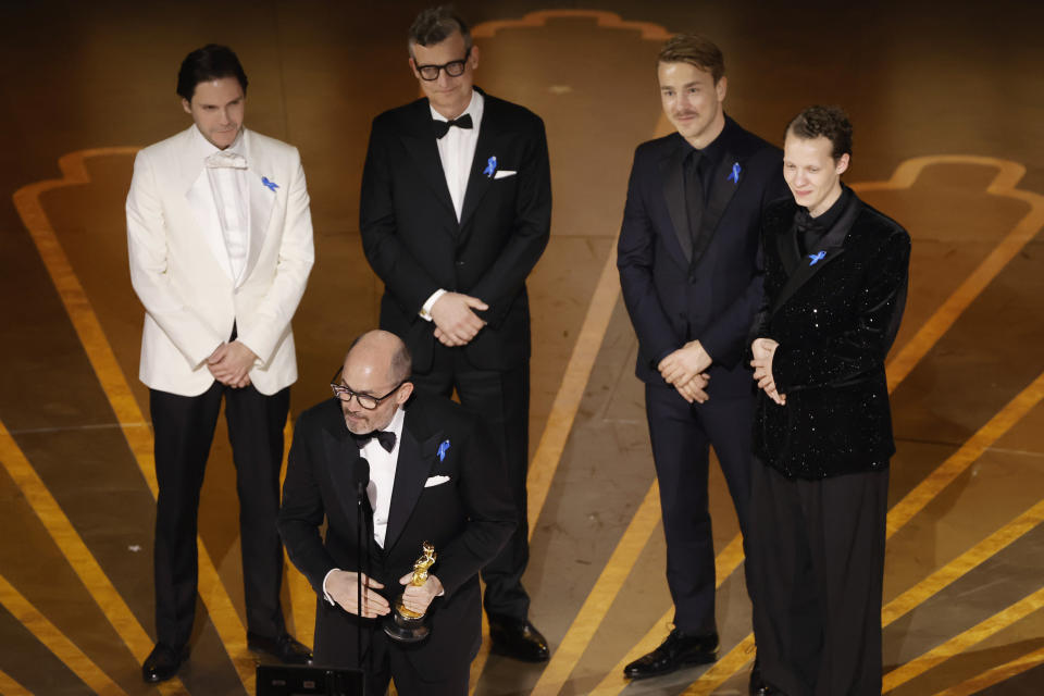 Daniel Brühl, Edward Berger, Malte Grunert, Albrecht Schuch, and Felix Kammerer accept the International Feature Film award for All Quiet on the Western Front at the Academy Awards on March 12.