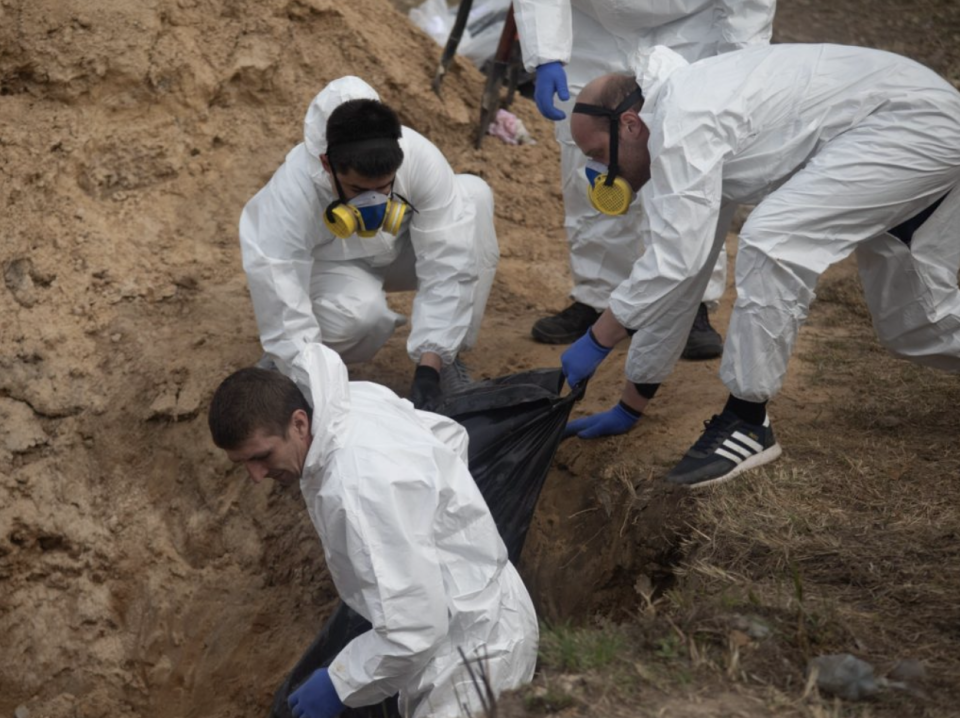 Rettungskräfte ziehen eine Leiche aus einem Massengrab in Butscha, Ukraine. - Copyright: Erin Trieb/Business Insider