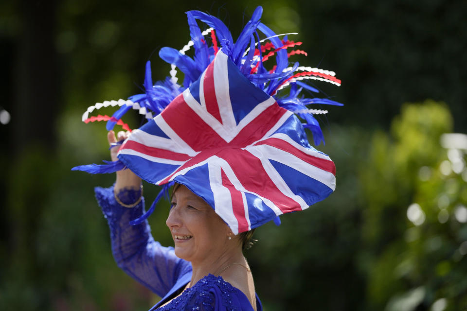 A racegoer poses for a photo, on the third day of the Royal Ascot horserace meeting, at Ascot Racecourse, in Ascot, England, Thursday, June 16, 2022. The third day is traditionally known as Ladies Day. (AP Photo/Alastair Grant)