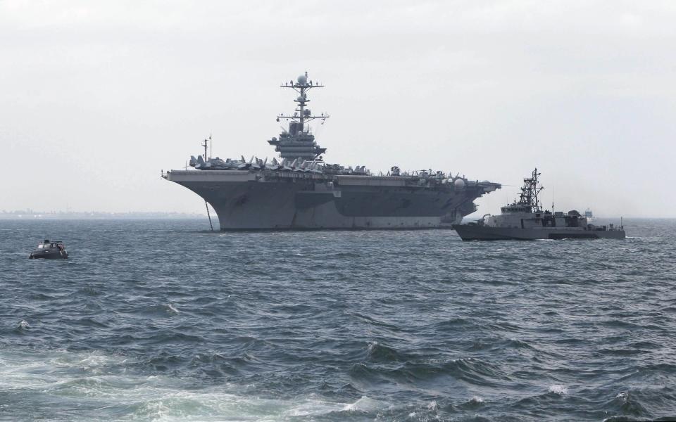 File photo of Philippine Navy patrol boat sailing past the U.S. Navy aircraft carrier George Washington docked after its arrival at a Manila bay