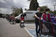 Customers wear face masks as they line up to enter a supermarket keeping social distancing following the government's measures to help stop the spread of the coronavirus, in Tel Aviv, Israel, Tuesday, April 7, 2020. Israeli Prime Minister Benjamin Netanyahu announced Monday a complete lockdown over the upcoming Passover holiday to control the country's coronavirus outbreak, but offered citizens some hope by saying he expects to lift widespread restrictions after the week-long festival. (AP Photo/Oded Balilty)
