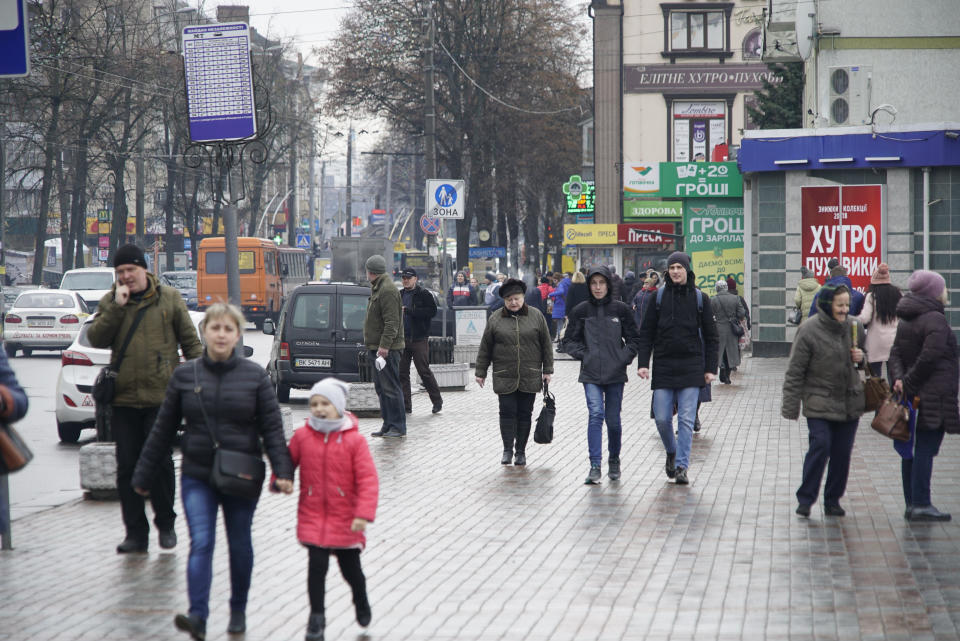 People walk along the street of Rivne, Ukraine, on March 14, 2019. As Ukrainians prepare to go to the polls in a presidential election March 31, millions of Ukrainians have already voted with their feet by leaving the country, seemingly mired in corruption, poverty and conflict. (AP Photo/Mstyslav Chernov)