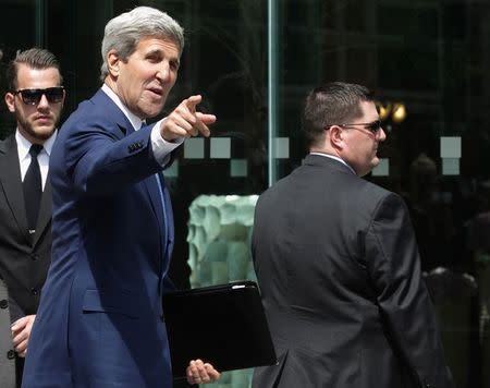 U.S. Secretary of State John Kerry (2nd L) points to journalists as he walks to a meeting on the second straight day of talks over Tehran's nuclear program at a hotel in Vienna July 14, 2014. REUTERS/Heinz-Peter Bader