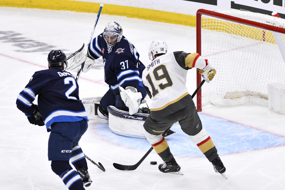Winnipeg Jets goaltender Connor Hellebuyck (37) makes a save against Vegas Golden Knights' Reilly Smith (19) during first-period Game 4 NHL Stanley Cup first-round hockey playoff action in Winnipeg, Manitoba, Monday April 24, 2023. (Fred Greenslade/The Canadian Press via AP)