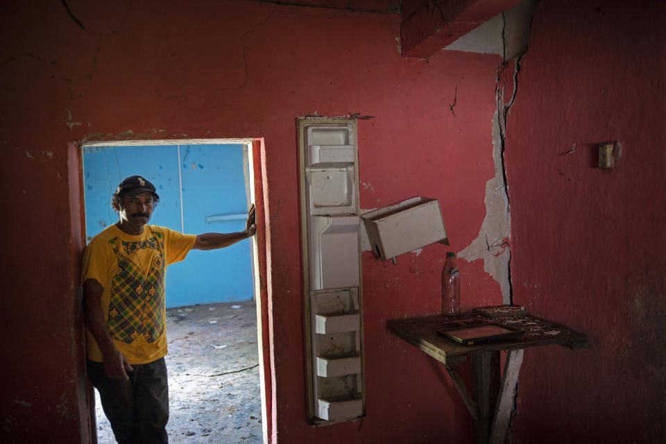 Orlando Perdomo, 56, stands for a portrait in his home damaged by a landslide triggered by hurricanes Eta and Iota, in the village of La Reina, Honduras, Sunday, June 20, 2021. “When the first cracks in the earth opened after Hurricane Mitch in 1998, my father said he wouldn’t live to see it, but that we would see the town disappear, that the future would bring death,” Perdomo recalls. (AP Photo/Rodrigo Abd)