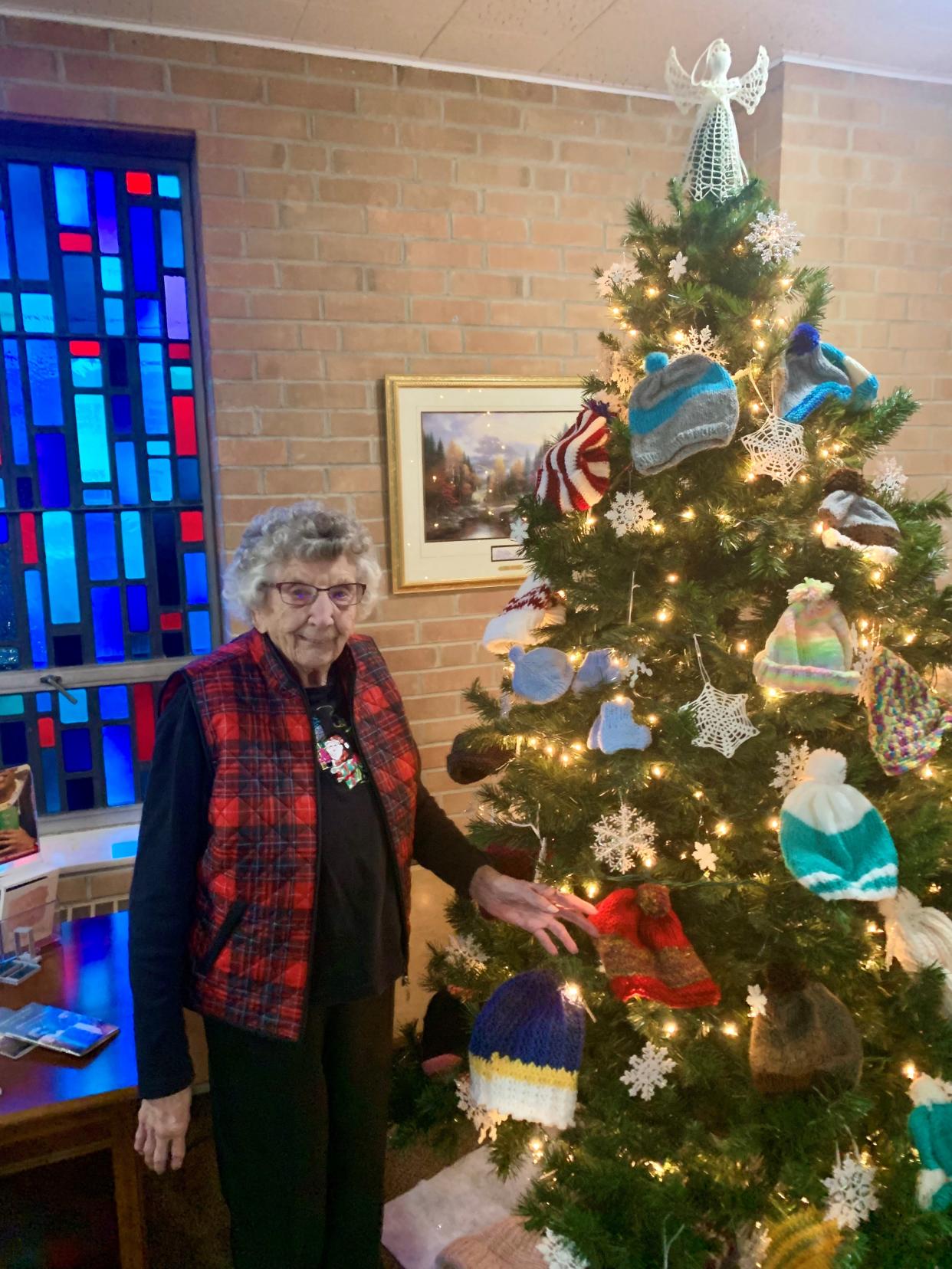 Virginia Meister shows off one of her knitted hats that adorn a special giving tree at Good Hope Lutheran Church. The hats will be distributed by the Salvation Army to area children in need.