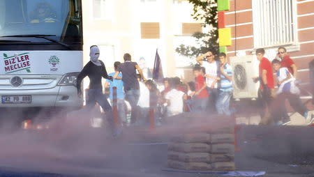 Demonstrators run away from tear gas used by riot police to disperse them during a march in solidarity with Kurdistan Workers Party (PKK)'s jailed leader Abdullah Ocalan in Diyarbakir, Turkey, August 1, 2015. REUTERS/Umit Bektas