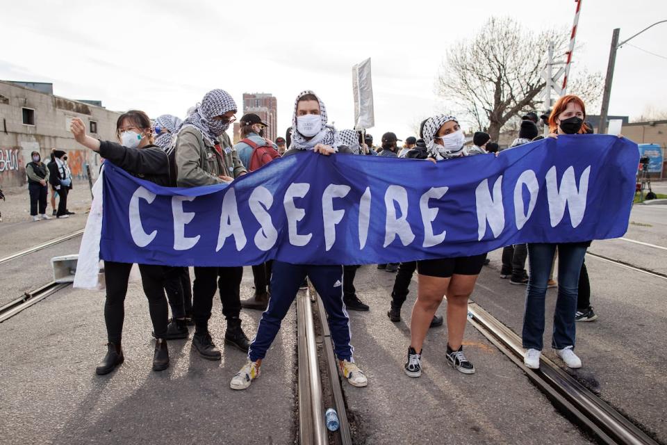 On April 16, 2024, protesters blocked the Toronto rail line at a rally organized by World Beyond War.  (Evan Mitsui/CBC - image credit)