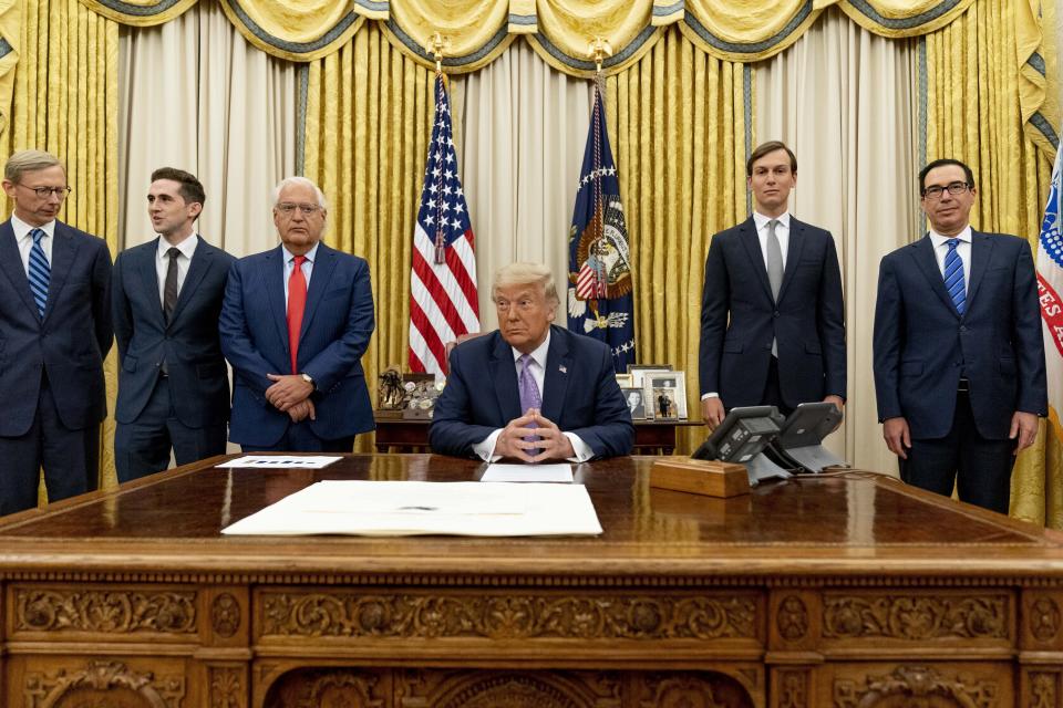 FILE - In this Aug. 12, 2020, file photo, President Donald Trump, center, accompanied by from left, U.S. special envoy for Iran Brian Hook, Avraham Berkowitz, Assistant to the President and Special Representative for International Negotiations, U.S. Ambassador to Israel David Friedman, President Donald Trump's White House senior adviser Jared Kushner, and Treasury Secretary Steven Mnuchin, sits in front of documents in the Oval Office at the White House in Washington. The agreement between the United Arab Emirates and Israel to establish full diplomatic ties comes as little surprise to those closely following the nuances of Middle East politics, and Trump administration’s almost single-minded push to broker a deal of this kind without a resolution first to the Israeli-Palestinian conflict. (AP Photo/Andrew Harnik, File)