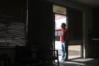 Strong Santa Ana winds in Chatsworth, Calif., blew across power lines causing them to arc and transformers to explode. Power was out for street signs, businesses and residents. Dan Rosen stands in the doorway of his Edward Jones investment office in Chatsworth on Thursday, Oct. 10, 2019. (Dean Musgrove/The Orange County Register via AP)