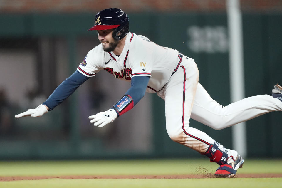 Atlanta Braves catcher Travis d'Arnaud (16) dives into second with with a two-run double in the third inning of a baseball game against the Cincinnati Reds Friday, April 8, 2022, in Atlanta. (AP Photo/John Bazemore)