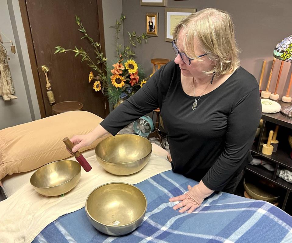 Gale Simon, owner of Acoustic Therapy Partners in Erie, demonstrates the harmony her therapeutic singing bowls make when struck one at a time on Jan. 4, 2023.