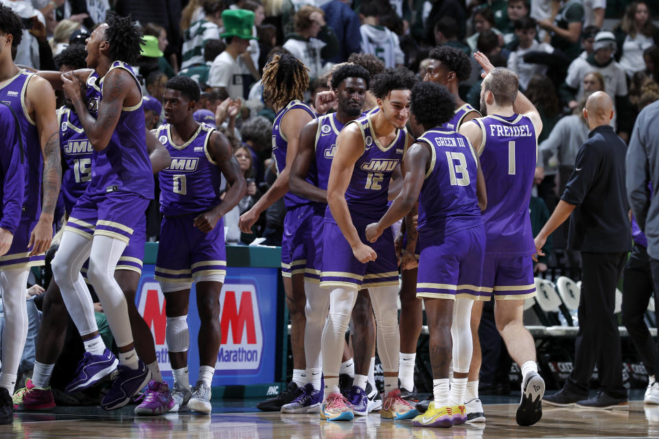 James Madison players celebrate after upsetting Michigan State in an NCAA college basketball game, Monday, Nov. 6, 2023, in East Lansing, Mich. (AP Photo/Al Goldis)