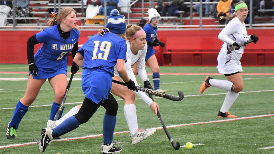 Clinton Comet Lauren Rey slips between Mt. Markham defenders Brooke Champagne (19) and Virginia Culver (9) Sunday during Section III's Class C final.