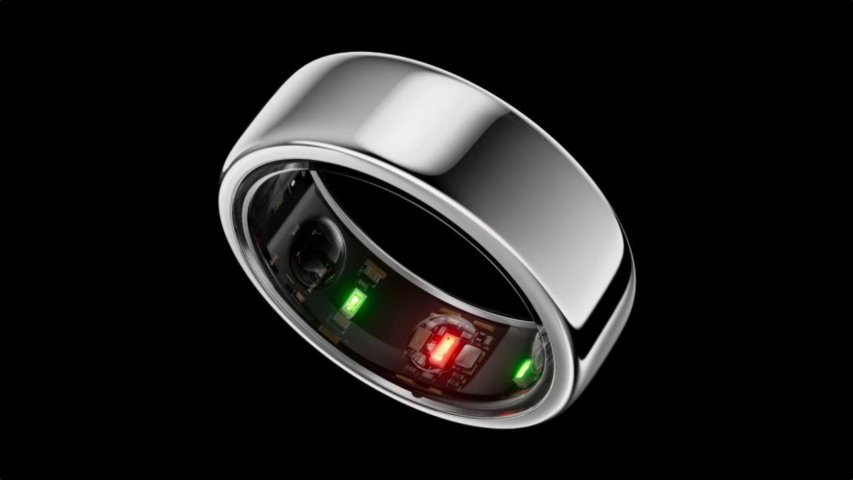  A close up of the Oura ring on a black background. 