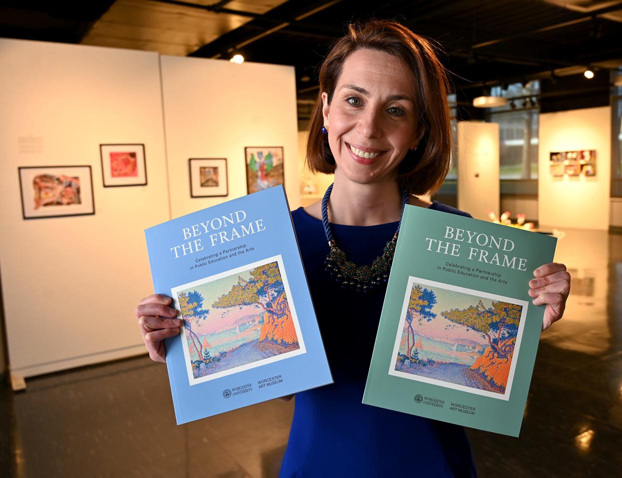Heather Treseler, an English professor at Worcester State, holds copies of "Beyond the Frame," a collaborative project between WSU and Worcester Art Museum.