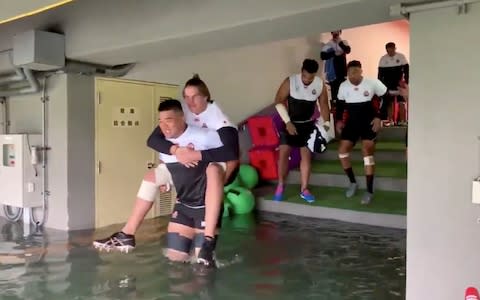 Japan's national rugby team waded through floodwater to reach the pitch for practice, with a decision still to be made on Sunday's matches - Credit: Japan Rugby Football Union/Reuters