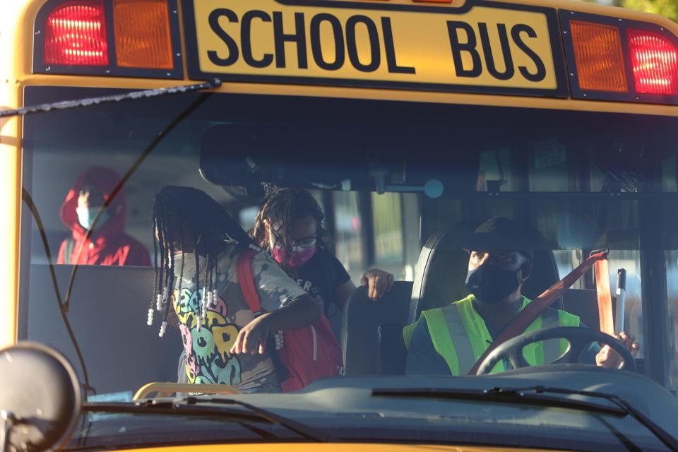 A driver watches as kids depart the school bus in Rochester, New York, on Sept. 9.