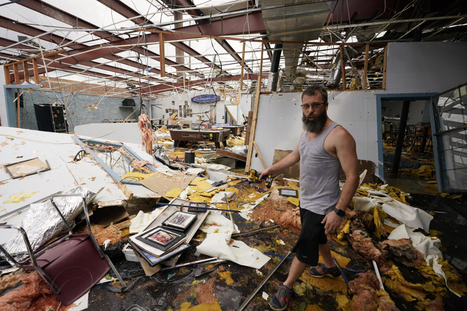 Jason Ledet relieves a tool as he works in a destroyed bowling alley as they try to recover from the effects of Hurricane Ida Tuesday, Aug. 31, 2021, in Houma, La. (AP Photo/Steve Helber)