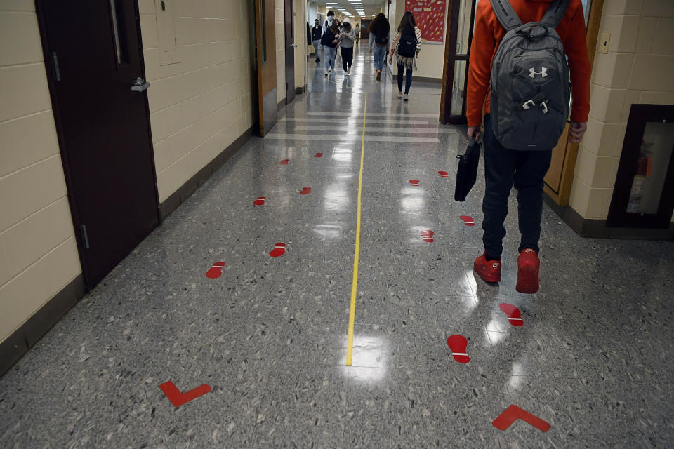 FILE - In this March 18, 2021, file photo, students stay distanced and in separate lanes when passing between classes at Windsor Locks High School in Windsor Locks, Conn. A new survey from the Biden administration finds that large numbers of students are not returning to the classroom even as more schools reopen for full-time, in-person learning. (AP Photo/Jessica Hill, File)