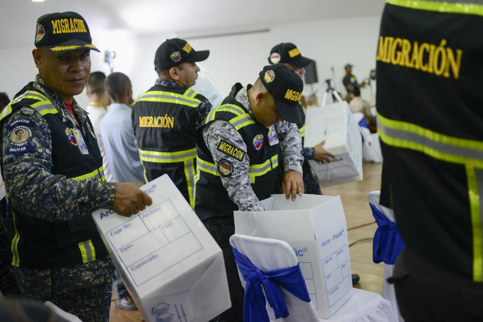 Members of Bolivarian Immigration National Police receive biosafety supplies that include infrared thermometers, protective masks and gloves, as part of preparations to help prevent the spread of the new coronavirus, at the National Experimental Security University in Caracas, Venezuela, Friday, March 13, 2020. For most people, the new coronavirus causes only mild or moderate symptoms, such as fever and cough. For some, especially older adults and people with existing health problems, it can cause more severe illness, including pneumonia. (AP Photo/Matias Delacroix)