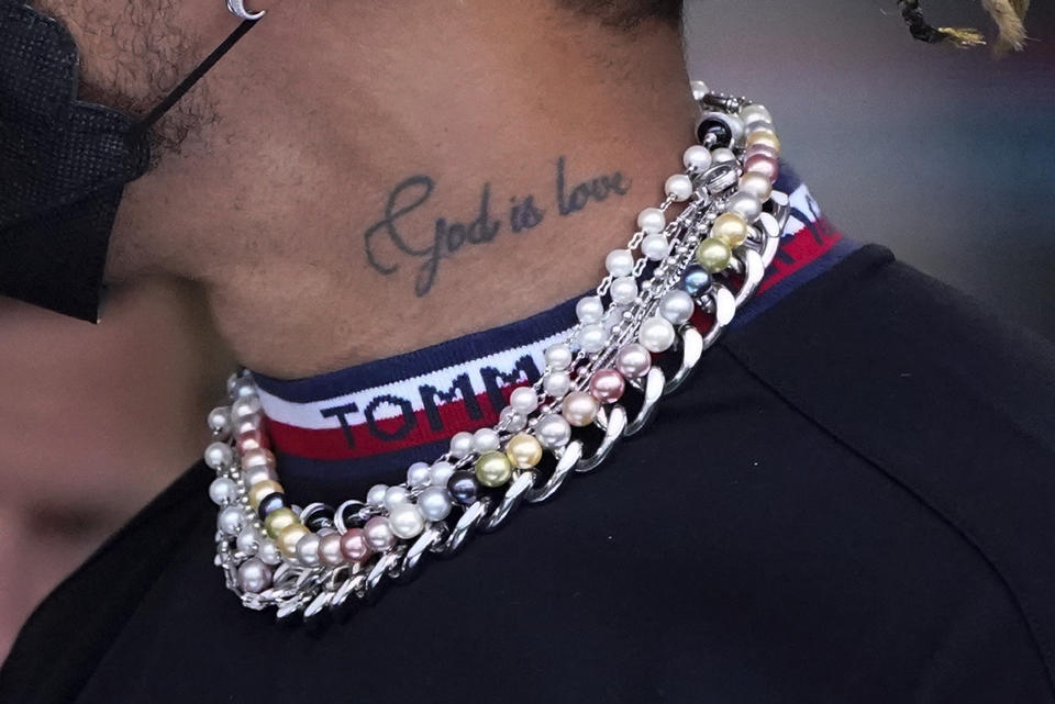 Mercedes driver Lewis Hamilton of Britain arrives for the first practice session for the Formula One Miami Grand Prix auto race wearing various items of jewelry at the Miami International Autodrome, Friday, May 6, 2022, in Miami Gardens, Fla. (AP Photo/Wilfredo Lee)