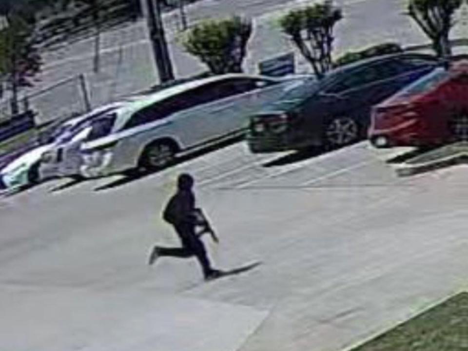 A still image released by Dallas Police shows a shooting suspect running in a parking lot after allegedly opening fire in a hair salon (Dallas Police Departmemt)