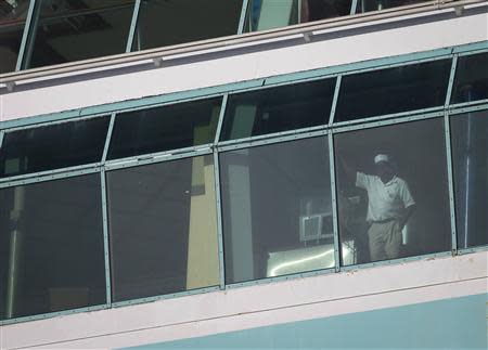 A worker looks out a window after Royal Caribbean's cruise ship, Explorer of the Seas arrived back at Bayonne, New Jersey January 29, 2014. REUTERS/Carlo Allegri