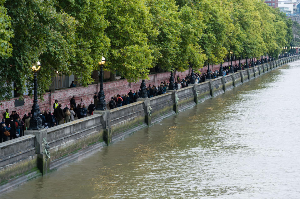 LONDON, UNITED KINGDOM - SEPTEMBER 15: A large queue stretches along the River Thames opposite Houses of Parliament in the early hours as mourners join the line to pay their respects to Queen Elizabeth II during the lying-in-state at Westminster Hall in London, United Kingdom on September 15, 2022. Hundreds of thousands of people are expected to file past the coffin of Queen Elizabeth II, 24 hours a day over the next four days ahead of the state funeral on Monday. (Photo by Wiktor Szymanowicz/Anadolu Agency via Getty Images)