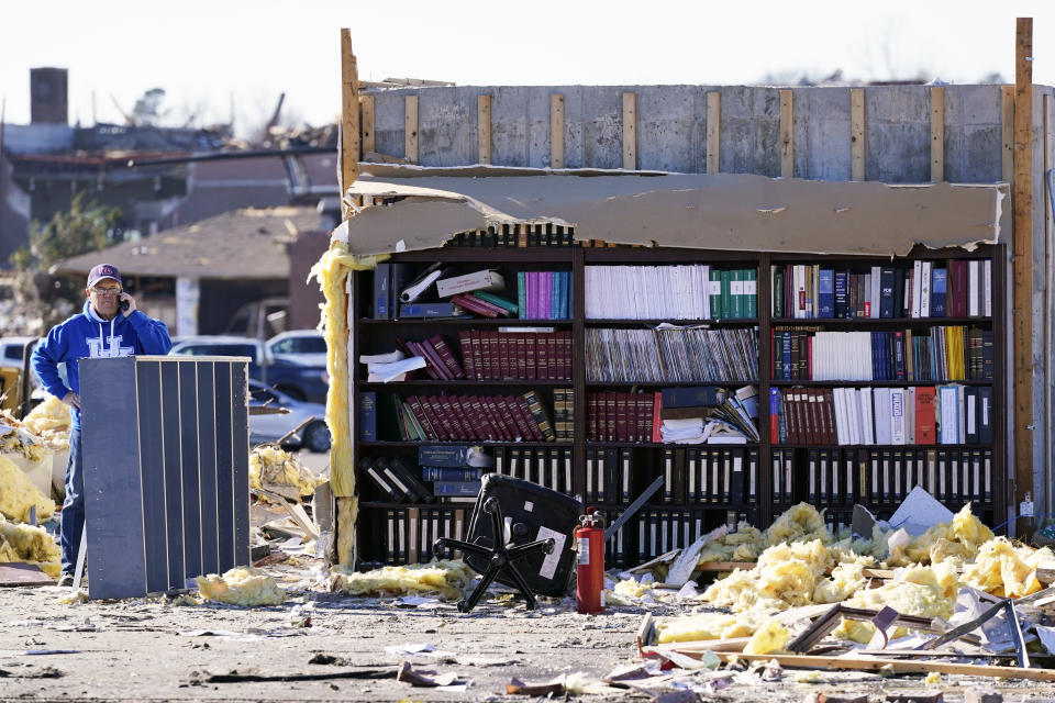 Attorney Chuck Foster talks on the phone Sunday, Dec. 12, 2021, in what was his law office before it was destroyed in Friday's storm in Mayfield, Ky. Tornadoes and severe weather caused catastrophic damage across several states Friday, killing multiple people. (AP Photo/Mark Humphrey)