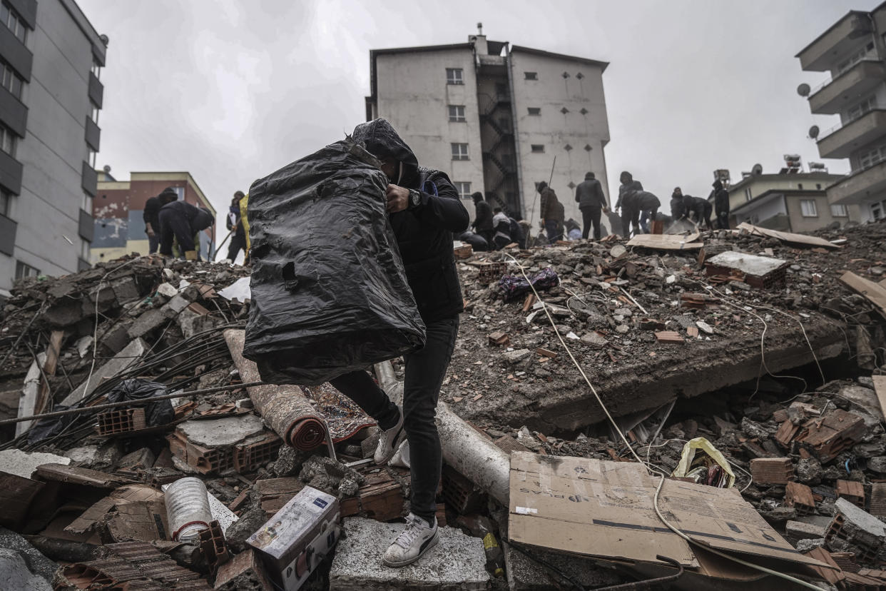 People and emergency teams search for people in the rubble in a destroyed building in Gaziantep, Turkey, Monday, Feb. 6, 2023. A powerful quake has knocked down multiple buildings in southeast Turkey and Syria and many casualties are feared. (AP Photo/Mustafa Karali)