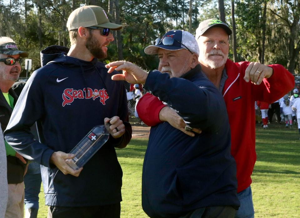 Boston Red Sox pitcher Chris Sale, a Lakeland High grad, talks with Mike Campbell, his former high school coach, as his father Allen Sale greets Campbell at the Evan Michael Chambers Baseball Camp on Saturday on at Curtis Peterson Park.