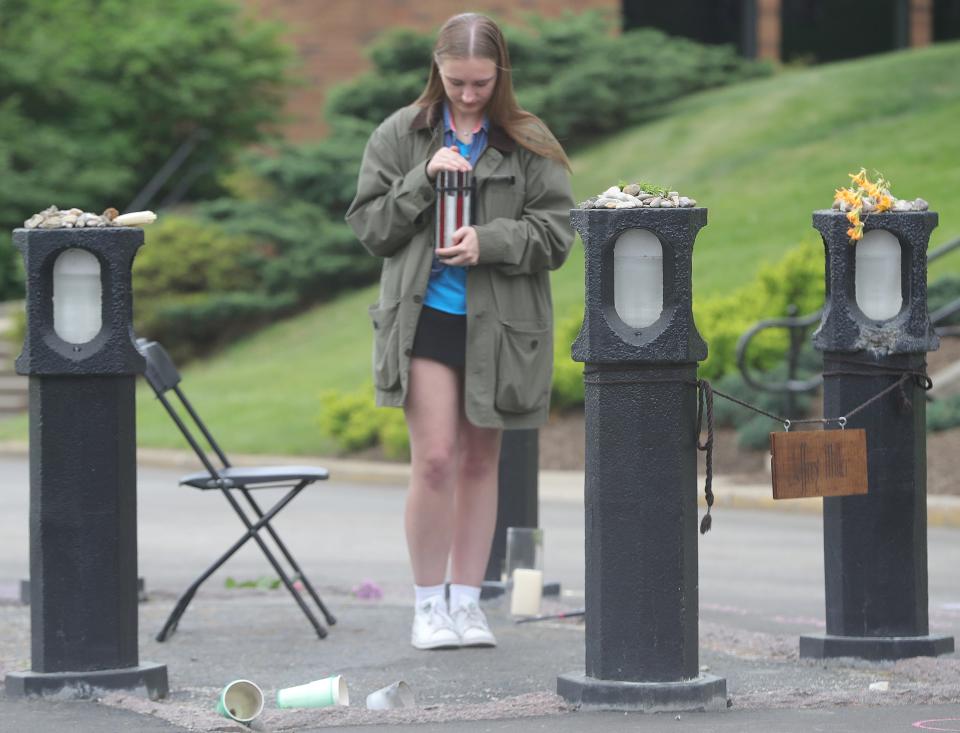 Kent State University freshman Peyton DeForce holds a candle Saturday on the site where Jeffrey Miller was shot by National Guardsmen on May 4, 1970. Saturday marked the 54th anniversary of the shooting.