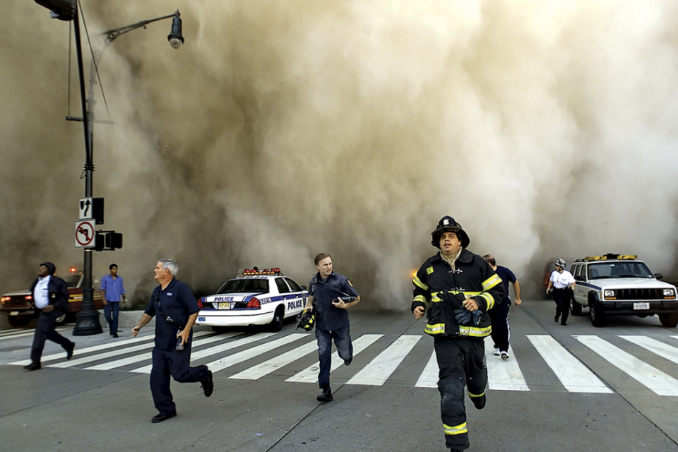 Policías, bomberos y otras personas huyen de las nubes de polvo. (Foto: Jose Jimenez/Getty)