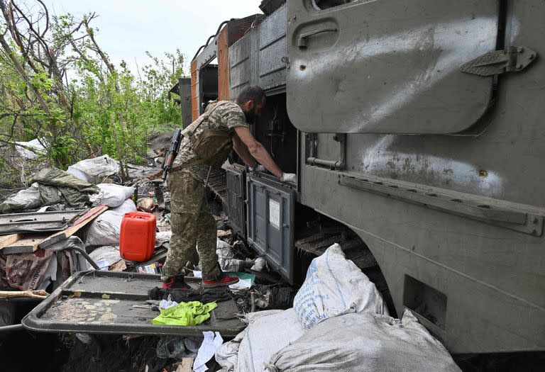 Un militar ucraniano inspecciona un vehículo militar ruso destruido cerca de la aldea de Mala Rogan al este de Kharkiv, el 13 de mayo de 2022