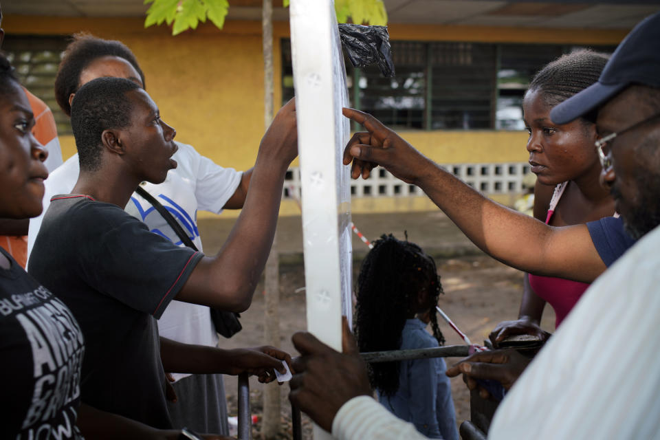 Congolese voters check the voters registration listings before voting in Kinshasa Sunday Dec. 30, 2018. Some forty million voters are registered for a presidential race plagued by years of delay and persistent rumors of lack of preparation. (AP Photo/Jerome Delay)