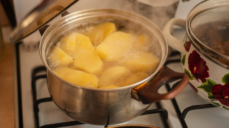 A pot of potatoes boiling on the stove