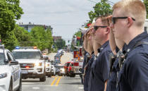 Champaign firefighters line University Avenue at First Street, in Champaign, Ill., Thursday, May 20, 2021, and salute as the motorcade passes by during a processional to take the casket carrying Champaign Police Officer Christopher Oberheim from Urbana to Decatur. Oberheim was shot early Wednesday during a shootout at an apartment complex. (Robin Scholz/The News-Gazette via AP)