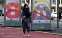 A pedestrian walks past an advertising billboard for the upcoming 70th Berlinale International Film Festival in Berlin