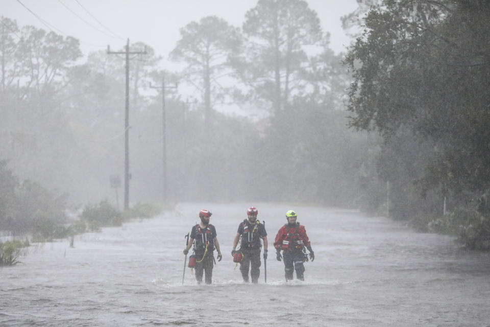 FILE - Rescue workers with Tidewater Disaster Response wade through a tidal surge on a highway while looking for people in need of help after the Steinhatchee River flooded on, Aug 30, 2023, in Steinhatchee, Fla., following the arrival of Hurricane Idalia. With warmer oceans serving as fuel, Atlantic hurricanes are now more than twice as likely as before to rapidly intensify from wimpy minor hurricanes to powerful and catastrophic, a study said Thursday, Oct. 19, 2023. (Douglas R. Clifford/Tampa Bay Times via AP, File)