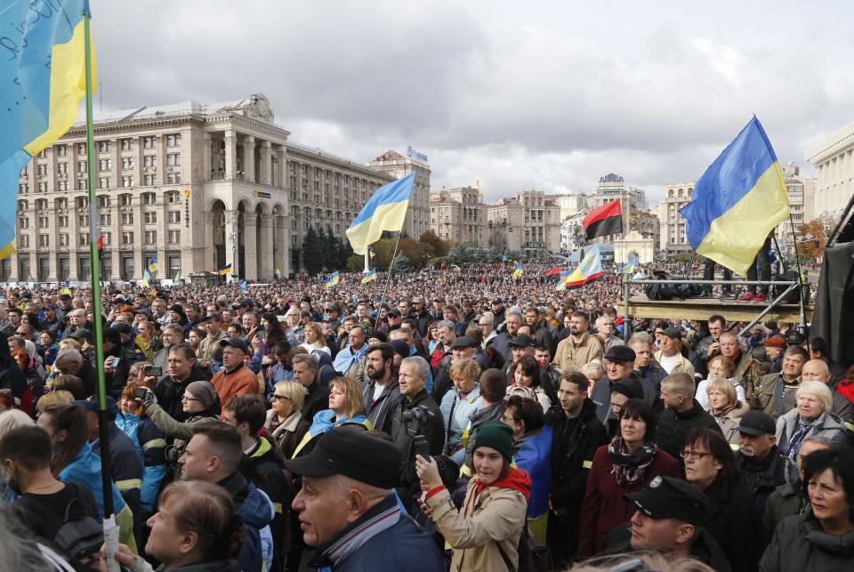 Protesters listen to a speaker during a rally in Independence Square in Kyiv, Ukraine, Sunday, Oct. 6, 2019. Thousands are rallying in the Ukrainian capital against the president's plan to hold a local election in the country's rebel-held east, a move seen by some as a concession to Russia. (AP Photo/Efrem Lukatsky)