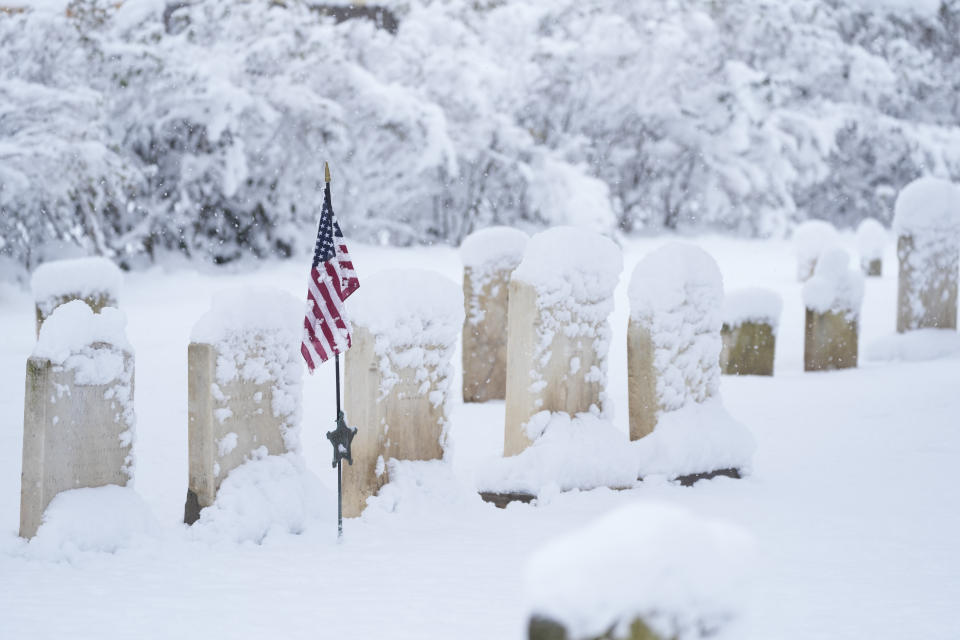 Snow covers gravestones during a winter snow storm in Doylestown, Pa., Tuesday, Feb. 13, 2024. (AP Photo/Matt Rourke)