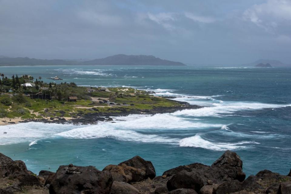 Surf breaks on Oahu’s coast. The weight of a tourism industry has ballooned to what many believe is beyond the islands’ capacity.