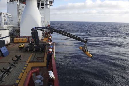 Operators aboard the Australian Defense Vessel Ocean Shield move the U.S. Navy's Bluefin 21 autonomous underwater vehicle into position for deployment in the Southern Indian Ocean, as the search continues for the missing Malaysia Airlines Flight 370, in this handout picture taken April 14, 2014. REUTERS/U.S. Navy/Mass Communication Specialist 1st Class Peter D. Blair/Handout via Reuters